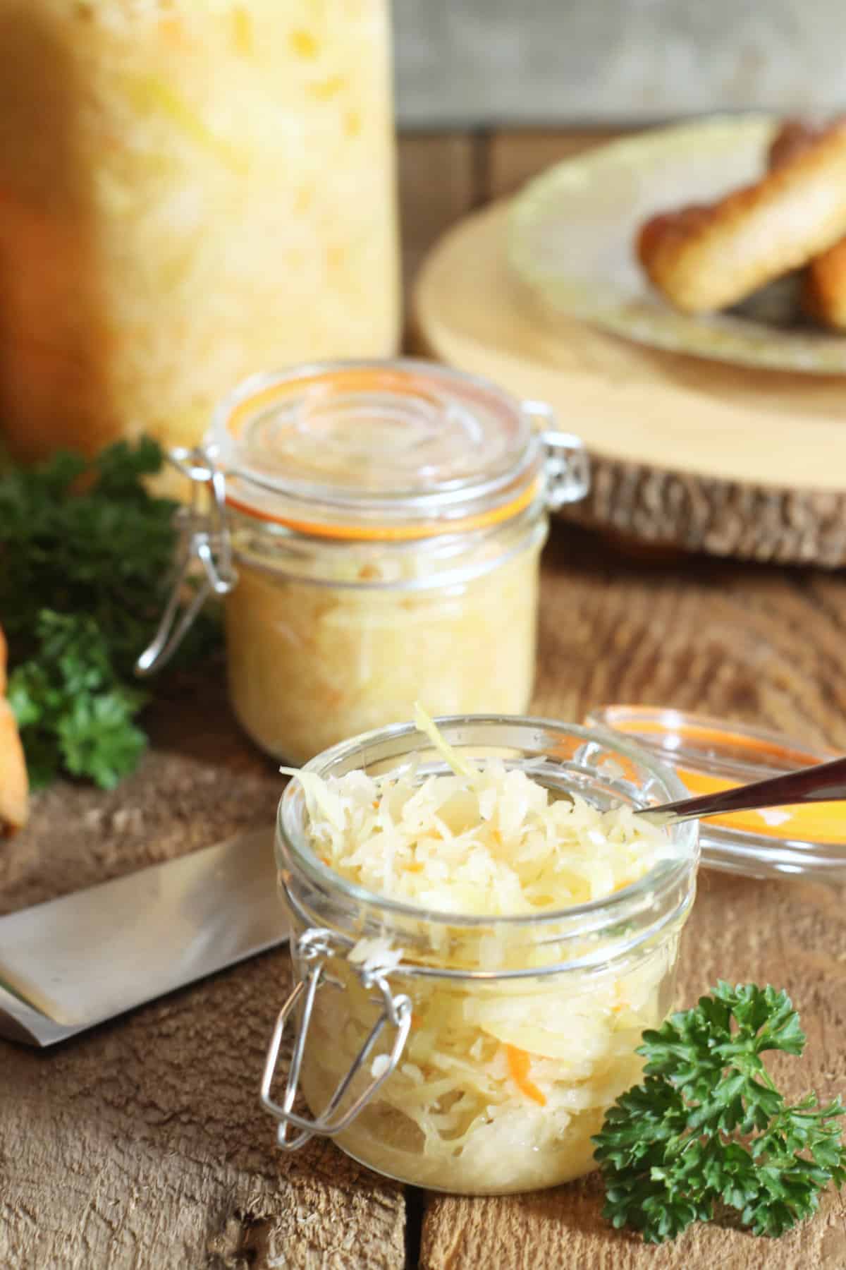 vertical image of fully fermented german sauerkraut packed into glass jars for storage.