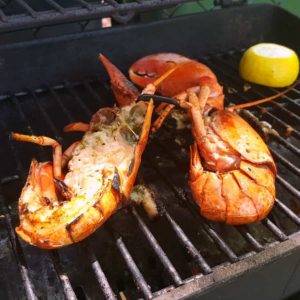 two blanched lobsters grilling on a BBQ is just one of the many ways lobster can be cooked