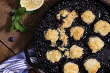 a cast iron pan filled with freshly baked blueberry grunt.