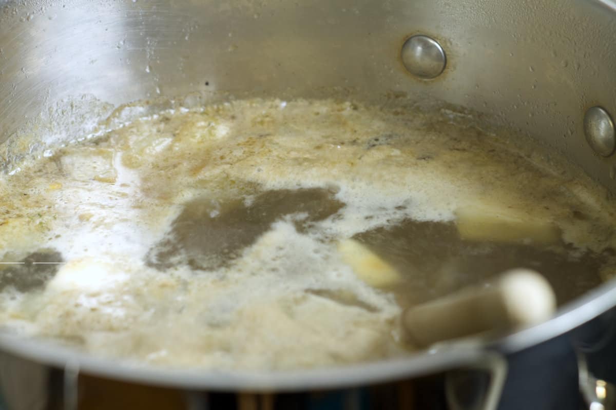 oxtail broth simmering with foam that needs to be skimmed of