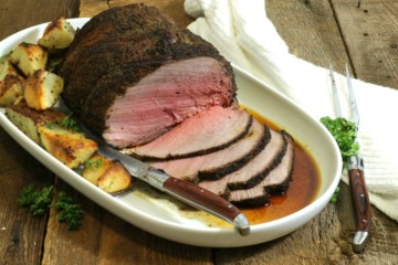 a sliced coffee rubbed sirloin tip roast on a white platter