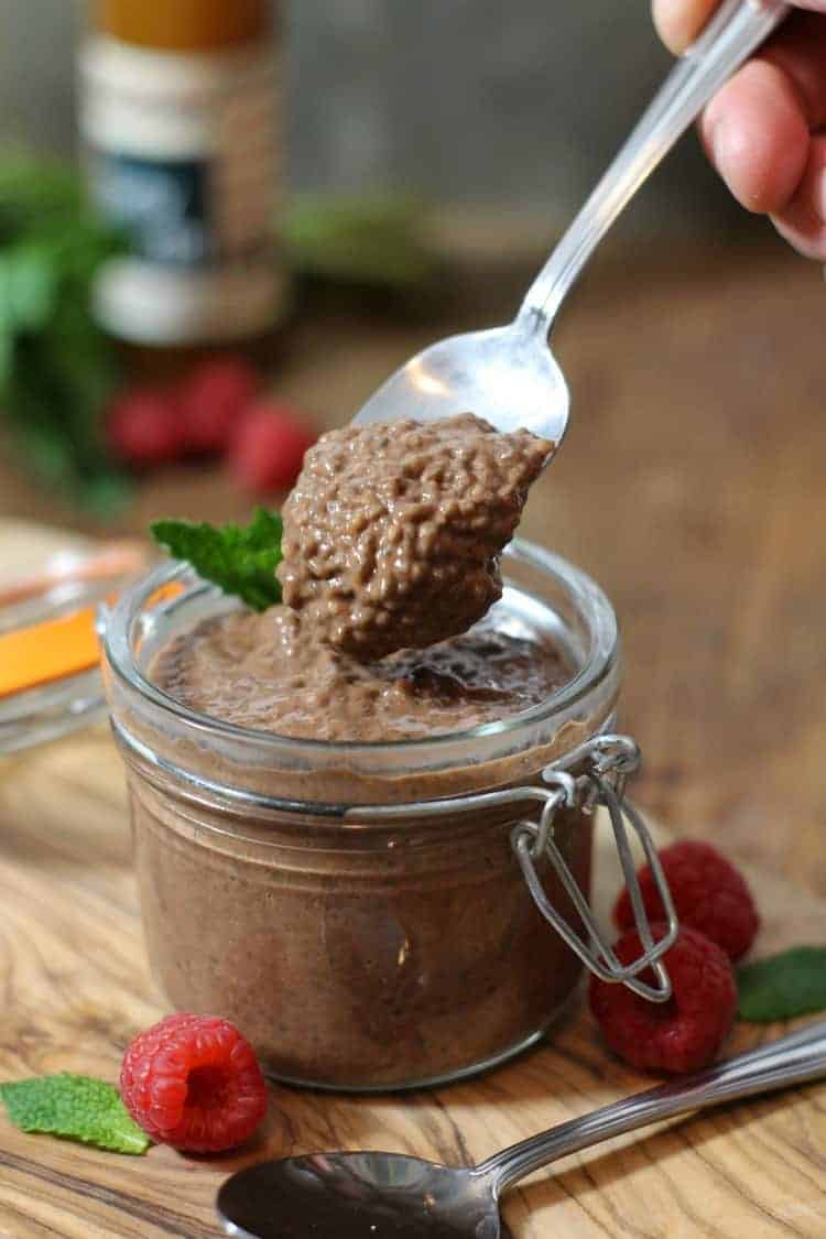 chocolate chia seed pudding being spooned out of a small mason jar