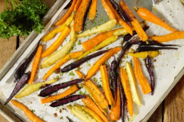 oven roasted baby carrots on a sheetpan garnished with chives