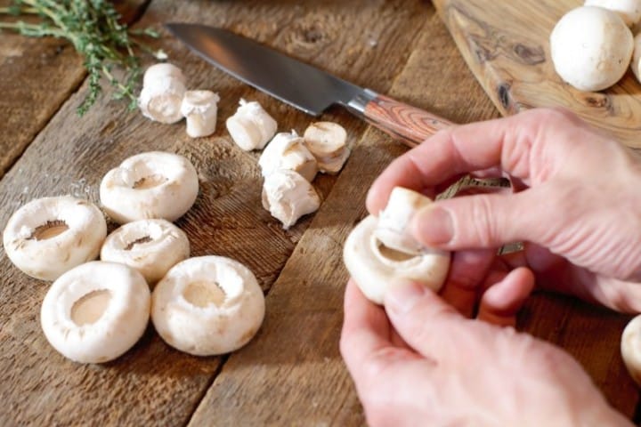 picking the stems out of large button mushrooms