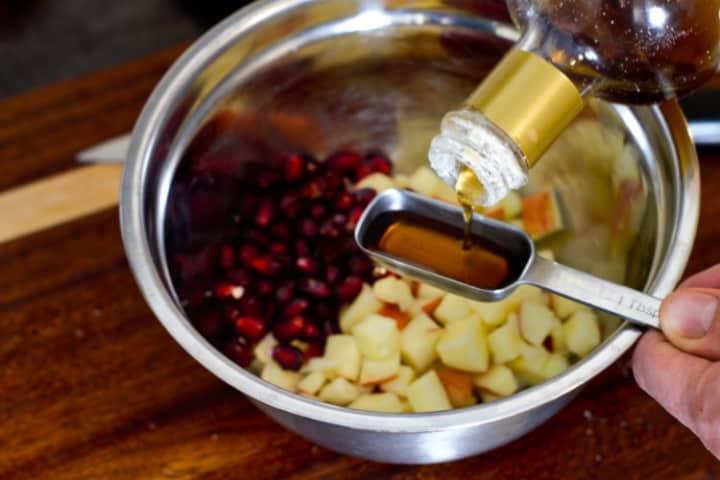 adding lemon and maple syrup tpo the fresh apple salad