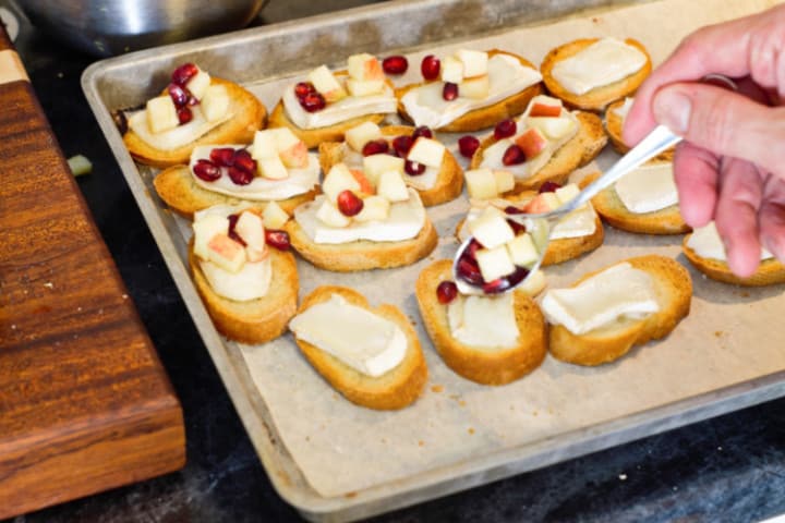 topping the warm brie crostini's with the apple salad