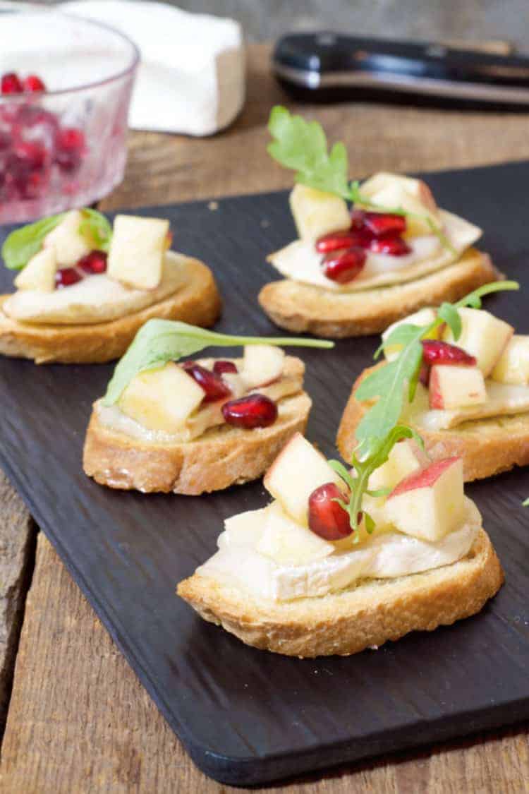 warm brie crostini's served on a black slate board