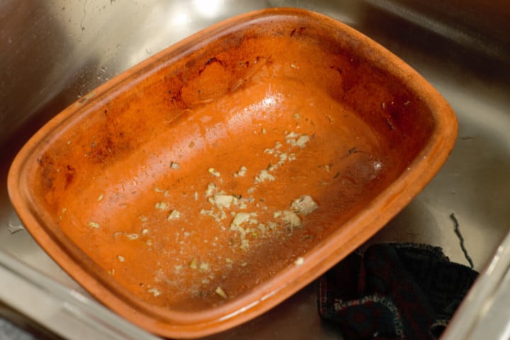 a dirty clay baker after using in a sink