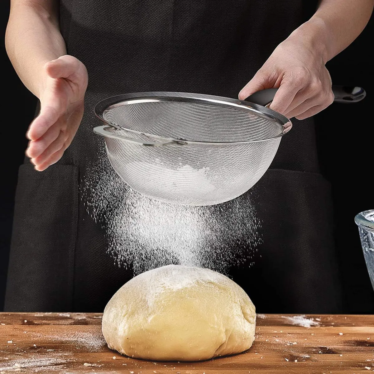 Chef sifting the flour on the dough using Stainless Steel 18/8 Extra Fine Sieve with Solid Sturdy Handle