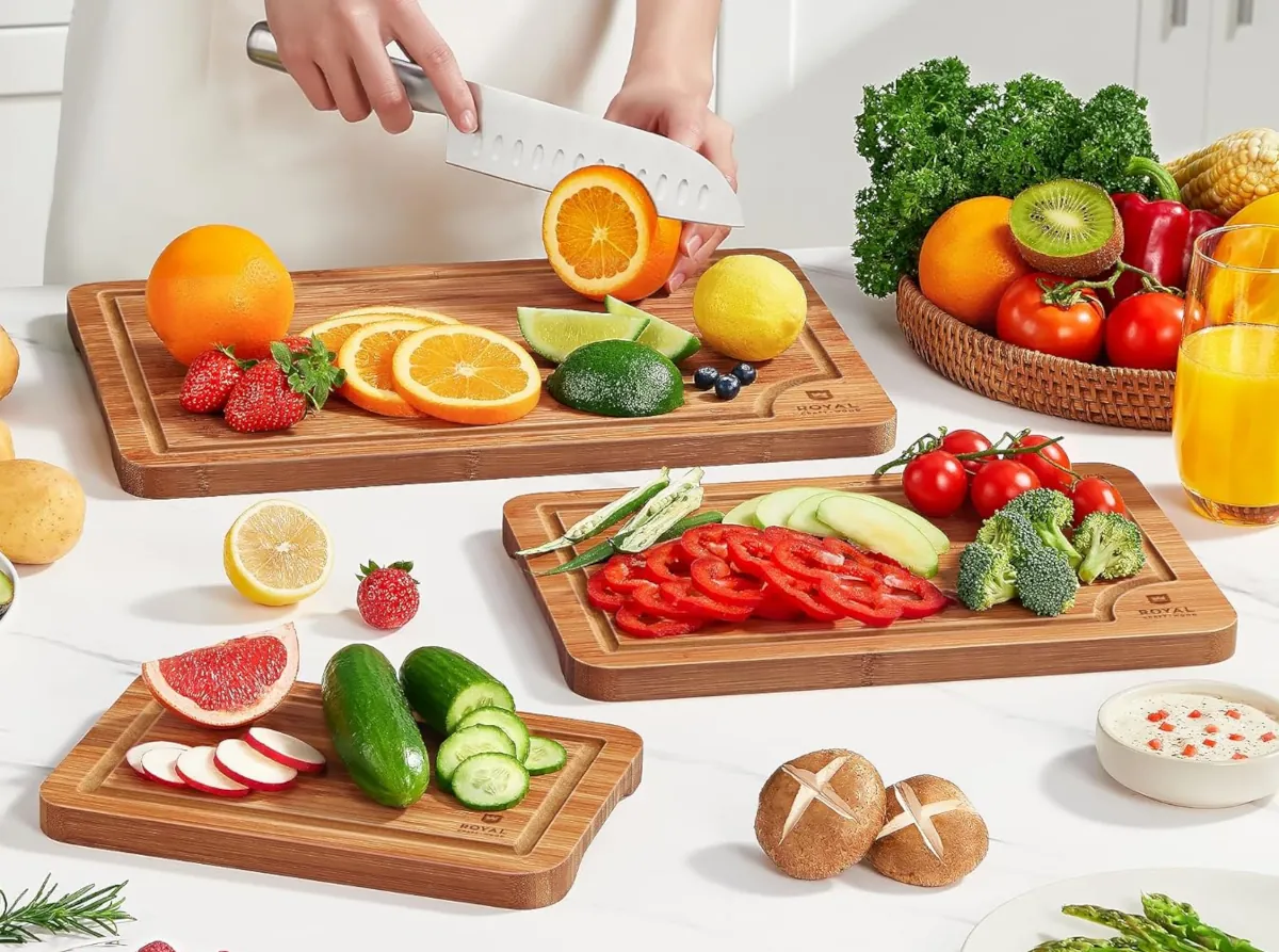 Person cutting fruit and vegetables on Wooden Cutting Boards for Kitchen Meal Prep & Serving with Deep Juice Groove and Side Handle