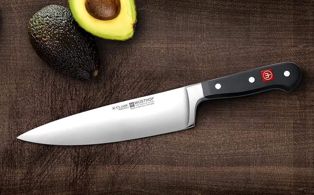 WÜSTHOF Classic 8 Inch Chef’s Knife, Black on chopping board with avocado