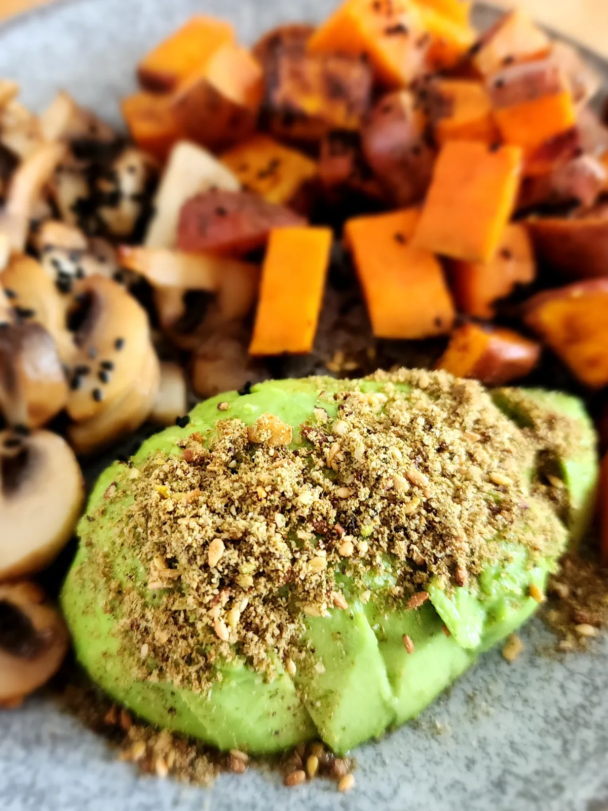 Dukkah sprinkled over avocado with roasted sweet potato and mushroom - vegan breakfast