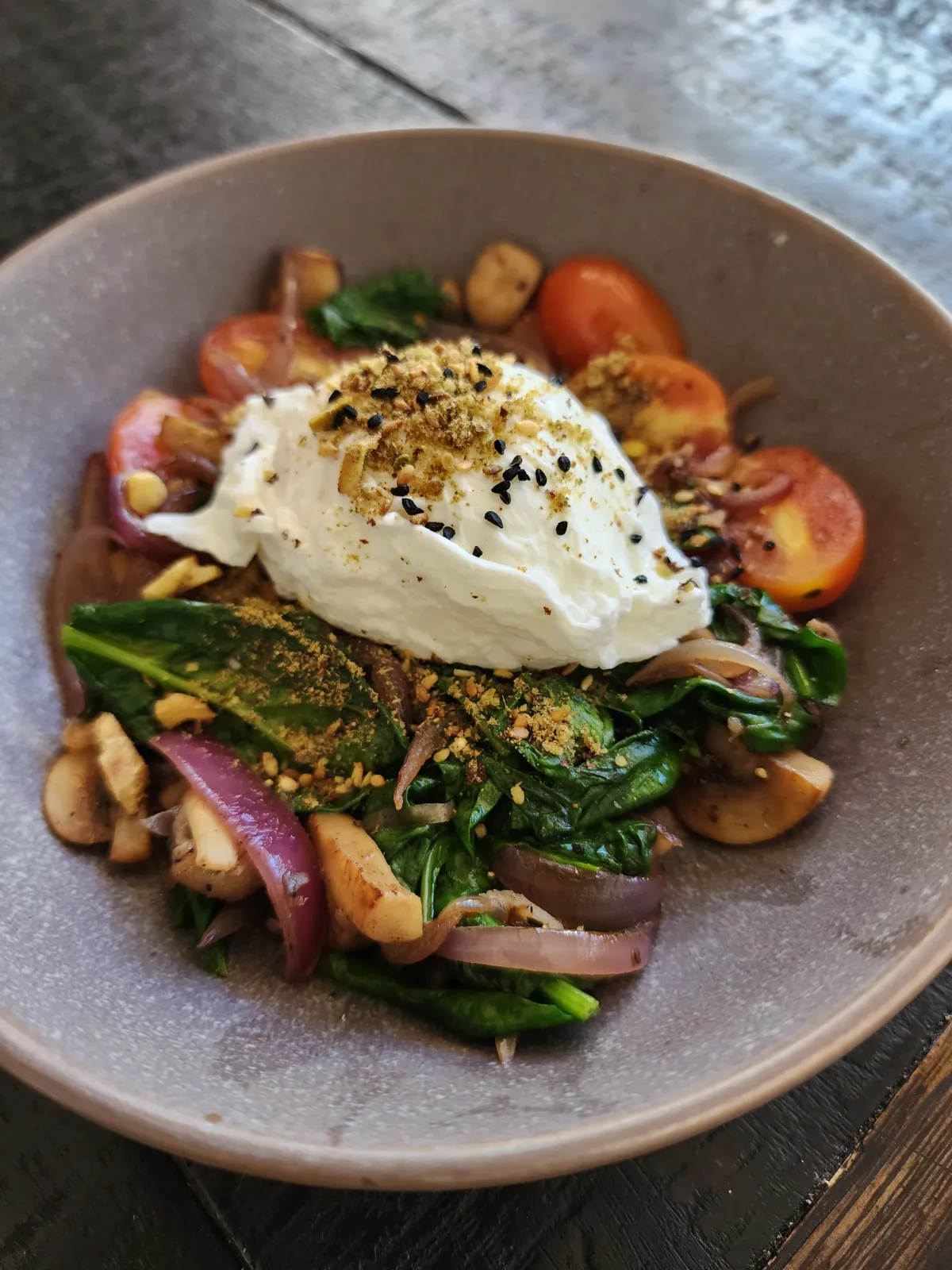 Dukkah on top of pouched egg with spinach mushroom, cherry tomato fry up breakfast